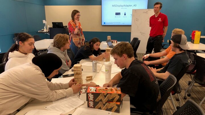 Professors Daniel Uden and Jenny Keshwani teach students with a Jenga game