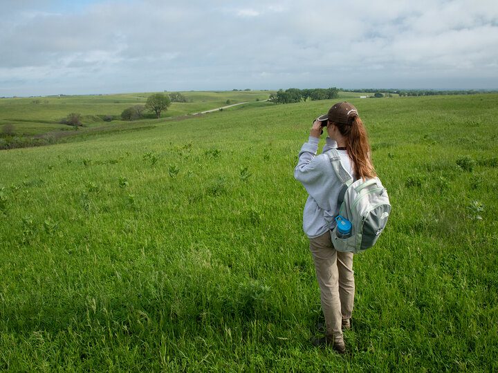 photo of a student looking through binoculars in the prairie corridor